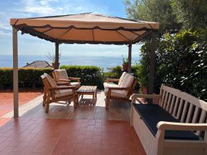 a patio with two chairs and an umbrella at "Villa degli Ulivi" 19th century Villa with private pool and sea view in Recco