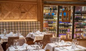 a restaurant with white tables and chairs and wine bottles at Natur- & Wellnesshotel Brunner Hof in Arnschwang