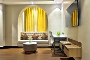 a living room with a couch in front of a window at Hotel Kant Palace in Tājganj