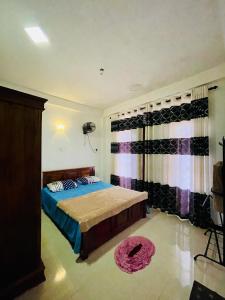 a bedroom with a bed and a window with curtains at Devil mountain guest in Kalupahana