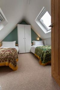 a attic bedroom with two beds and a window at Abbey Rectory - with private parking in Bath