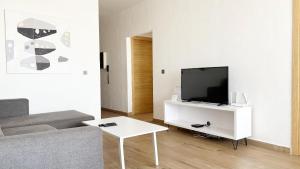 Una sala de estar con un sofá y un televisor. en Dakar By Days - DBD009 Appartement Anita 3 chambres, en Dakar