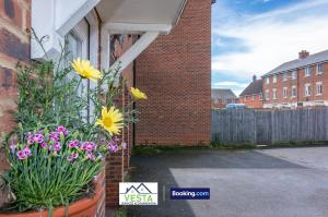 a pot of flowers on the side of a house at Three Bedroom Apartment By Vesta Serviced Accommodation & Short Lets Hatfield With Free Parking in Hatfield