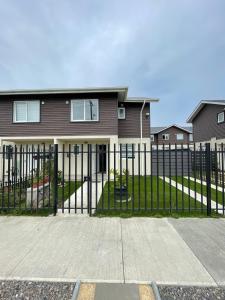 a black fence in front of a house at Acogedora casa cerca del mar in San Pedro de la Paz +11 photos