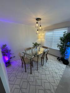 a dining room with a glass table and chairs at Acogedora casa cerca del mar in San Pedro de la Paz