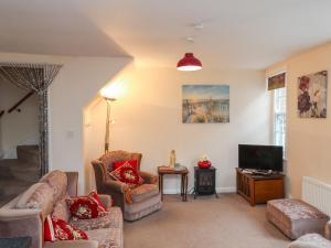 a living room with two couches and a tv at Caedmon's Rest in Whitby