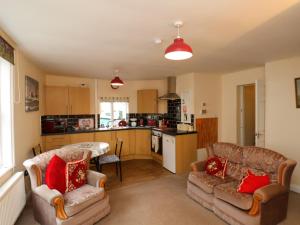 a living room with two couches and a kitchen at Caedmon's Rest in Whitby