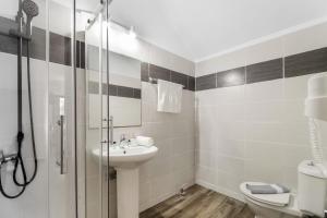a bathroom with a toilet and a sink and a shower at Dionysia Rooms in Lefkada