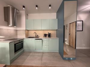 a kitchen with white cabinets and a sink at Jacuzzi Apartamenty Gdańsk - RELAX Apartments in Gdańsk +38 photos