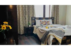 a bedroom with a bed and a vase of flowers at Olive Serviced Apartments - Defence Colony in New Delhi