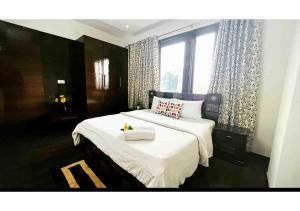 a bedroom with a large white bed with a window at Olive Serviced Apartments - Defence Colony in New Delhi +22 photos