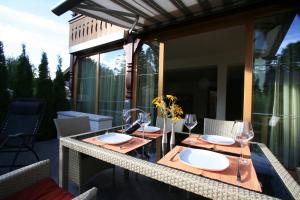 a table with glasses and plates on a balcony at Landhaus Alpenflair Whg 403 in Oberstdorf
