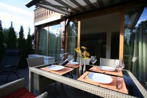 einen Tisch mit Gläsern und Tellern auf dem Balkon in der Unterkunft Landhaus Alpenflair Whg 403 in Oberstdorf