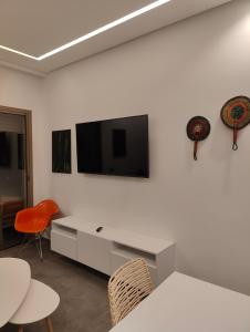 a white room with a tv and a table and chairs at Cocon moderne in Essaouira