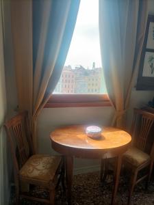 a table and two chairs in front of a window at Locanda Ai Santi Apostoli Sul Canal Grande - Ferretti Hotels Collection in Venice +85 photos