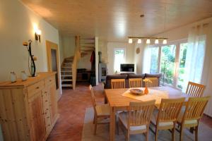 ein Esszimmer und ein Wohnzimmer mit Tisch und Stühlen in der Unterkunft Seweko - Ferienhaus am Donnerberg - Kamin & Küche in Wittstock + 14 Fotos