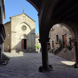 a building with a church with a clock on it at Boccaletto Incantato in Viterbo +5 photos