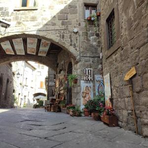 a stone building with an archway in a street at Boccaletto Incantato in Viterbo
