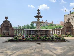 a fountain with flowers and a statue in a courtyard at Boccaletto Incantato in Viterbo