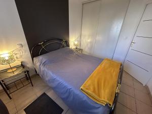 a small bedroom with a bed with a yellow blanket on it at Adour e vita in Pontonx-sur-lʼAdour