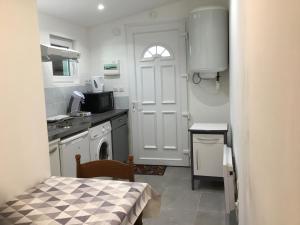 a small kitchen with a white door and a table at Maisonette bedogao in Valence
