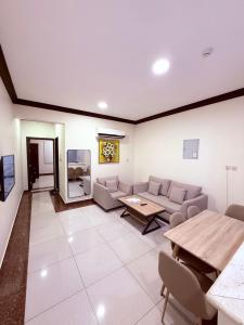 a living room with a couch and a table at شقق اجنحة الروزا للشقق المخدومة in Buraydah