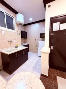 a kitchen with a sink and a black door at شقق اجنحة الروزا للشقق المخدومة in Buraydah