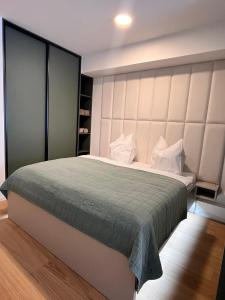 a bedroom with a large bed with a large headboard at VApartment Bratislava , private parking in Koliba
