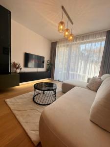 a living room with a couch and a table at VApartment Bratislava , private parking in Koliba