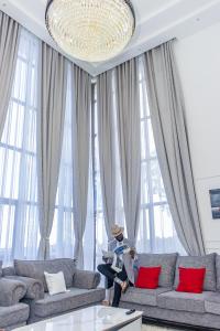 ナニュキにあるIvory Mansion, a luxurious 5br Villa nestled on 3acres with stunning views in Nanyukiのソファのあるリビングルームに立っている人