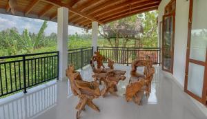 un porche con sillas de madera en el balcón en Kadalla Holiday Resort, en Rambukanagama
