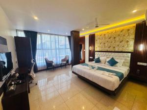 una camera da letto con un letto grande e una televisione di Mysore Elite a Mysore