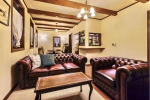 a living room with two leather couches and a table at アンティークス岐阜関 Antiques Gifu Seki in Sekimachi