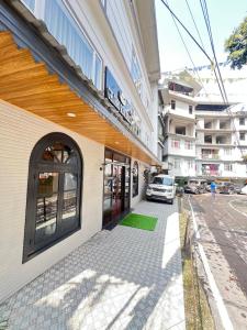 a building with a car parked next to a street at Ghasso Residency in Gangtok