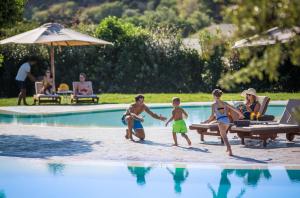 a group of people playing in a swimming pool at Chia Laguna - Hotel Village in Chia