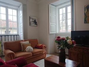 a living room with a couch and a vase of flowers at RUA NOVA APARTMENT, 3 Dormitorios, PS4 y Netflix, a 200m Catedral in Santiago de Compostela