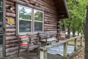 a cabin with two chairs and a bench on a porch at Nature's Nook - Fire Pit & Near Fishing & Golf in Eagle Rock