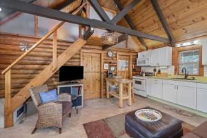 a kitchen and living room in a log cabin at Nature's Nook - Fire Pit & Near Fishing & Golf in Eagle Rock