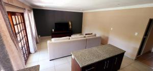 a living room with a couch and a tv at Gorgeous Garden Villa 3 in Gillitts