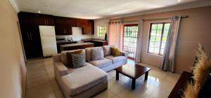 a living room with a couch and a table at Gorgeous Garden Villa 3 in Gillitts