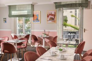 a restaurant with tables and chairs and a window at Best Western Hotel Lakmi Nice in Nice