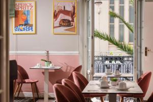 a restaurant with two tables and chairs and a window at Best Western Hotel Lakmi Nice in Nice