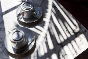 two tea pots sitting on a table in the sunlight at Best Western Hotel Lakmi Nice in Nice