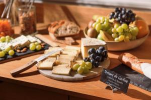 a table with a bunch of different types of cheese and grapes at Best Western Hotel Lakmi Nice in Nice