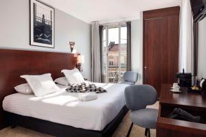 a bedroom with a large bed and a desk and chair at Best Western Hotel Lakmi Nice in Nice