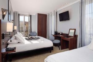 a hotel room with a bed and a desk and a mirror at Best Western Hotel Lakmi Nice in Nice
