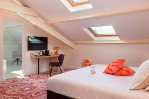 a bedroom with a bed and a desk with a television at Best Western Hotel Lakmi Nice in Nice