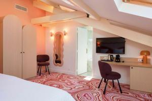 a bedroom with a bed and two chairs and a desk at Best Western Hotel Lakmi Nice in Nice