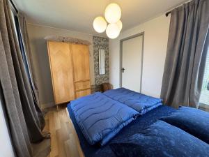 a bedroom with a bed with a blue comforter at Bungalowpark de Horn - 128 in Dirkshorn