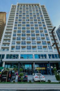 un grand bâtiment avec des voitures garées devant dans l'établissement Hygge VIP Haven by NEXT WHITE, à Batoumi